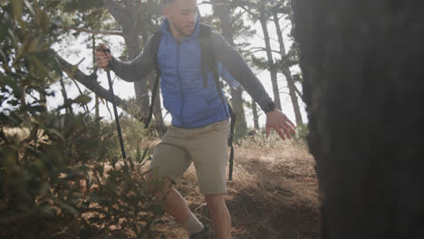 happy african american couple hiking with trekking poles in forest, slow motion