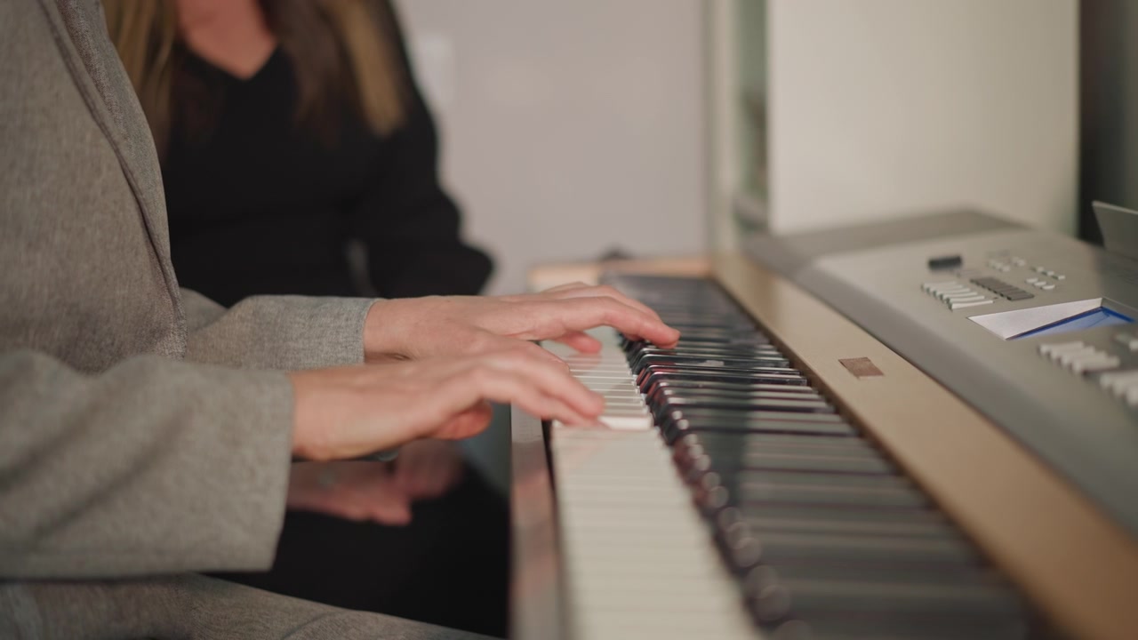 Prova in studio che mostra mani sincronizzate e pratica collaborativa. Due musicisti si esercitano insieme sotto una luce calda mentre ricevono coaching e condividono esibizioni espressive