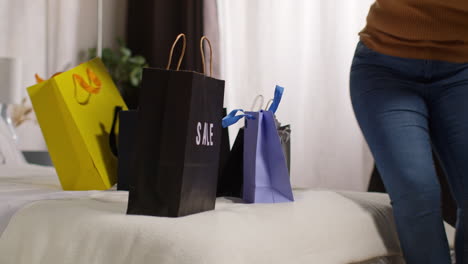 woman carrying shopping bags in bedroom