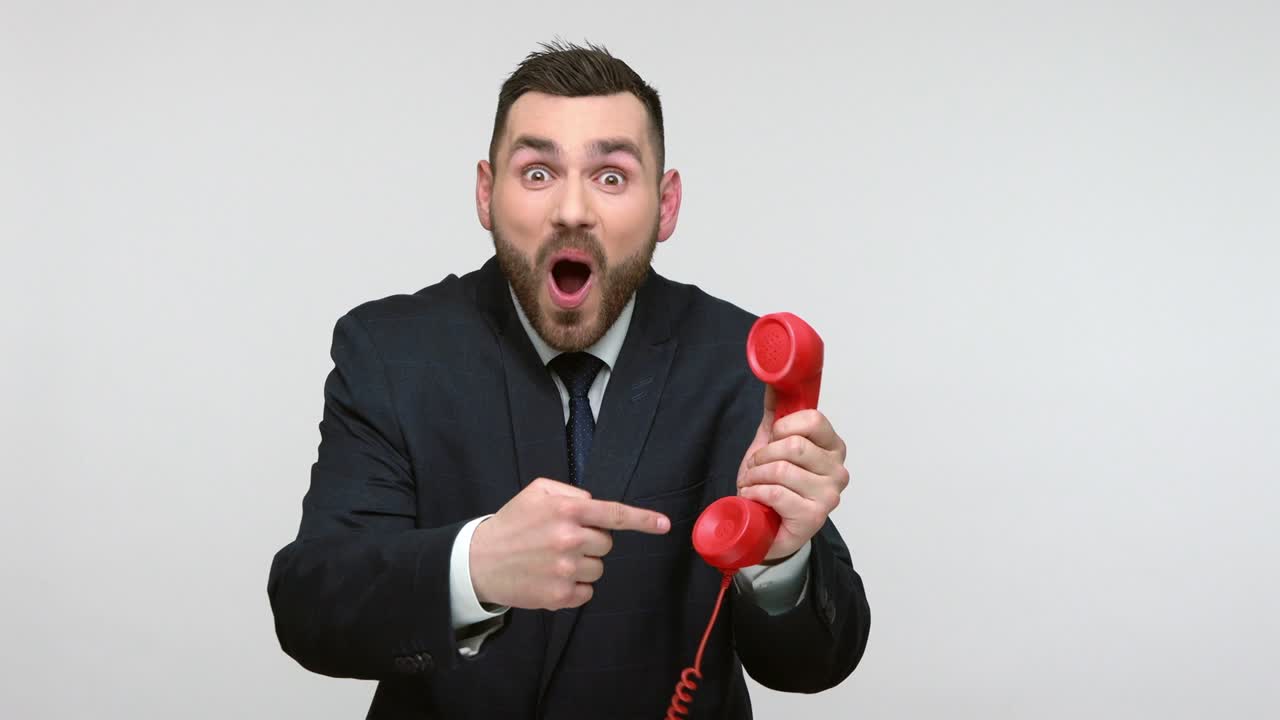 Man holding red handset and showing call me gesture.
