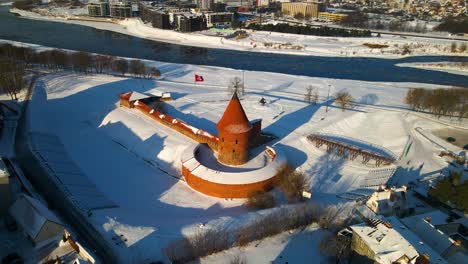 tomada de avión no tripulado del histórico castillo de ladrillo rojo de kaunas en el casco antiguo de kaunas, cerca del río neris, en lituania durante el frío invierno nevado