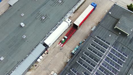 Trucks-with-semi-trailers-stand-on-the-parking-lot-of-the-logistics-park-with-loading-hub-and-wait-for-load-and-unload-goods-at-warehouse-ramps-at-sunset