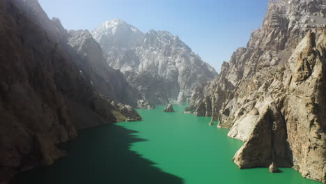 epic cinematic drone shot going through a large ravine over the kel-suu lake in kyrgyzstan