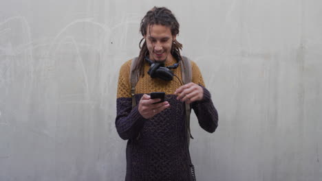 Porträt-Eines-Glücklichen-Jungen-Mannes,-Der-Ein-Smartphone-Verwendet-Und-Das-Surfen-Im-Internet-Beim-Lesen-Von-Textnachrichten-Genießt.-Sorgloser-Mann-Mit-Dreadlocks-Frisur,-Mobiler-Technologie