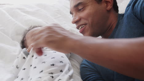 Cerca-De-Un-Padre-Milenario-Afroamericano-Acostado-En-La-Cama-Jugando-Con-Su-Hijo