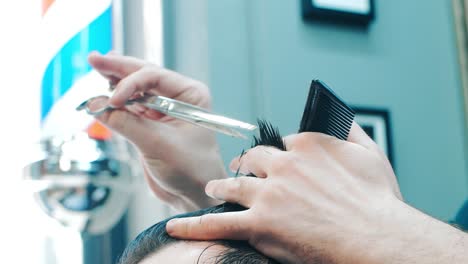 Barber-using-scissors-and-comb-during-making-hairdo.-Modern-hair-salon-concept