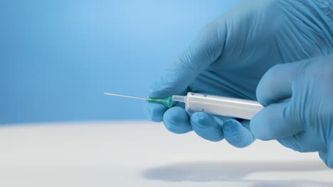 el médico con guantes fija la aguja a la jeringa de inyección médica en cámara lenta