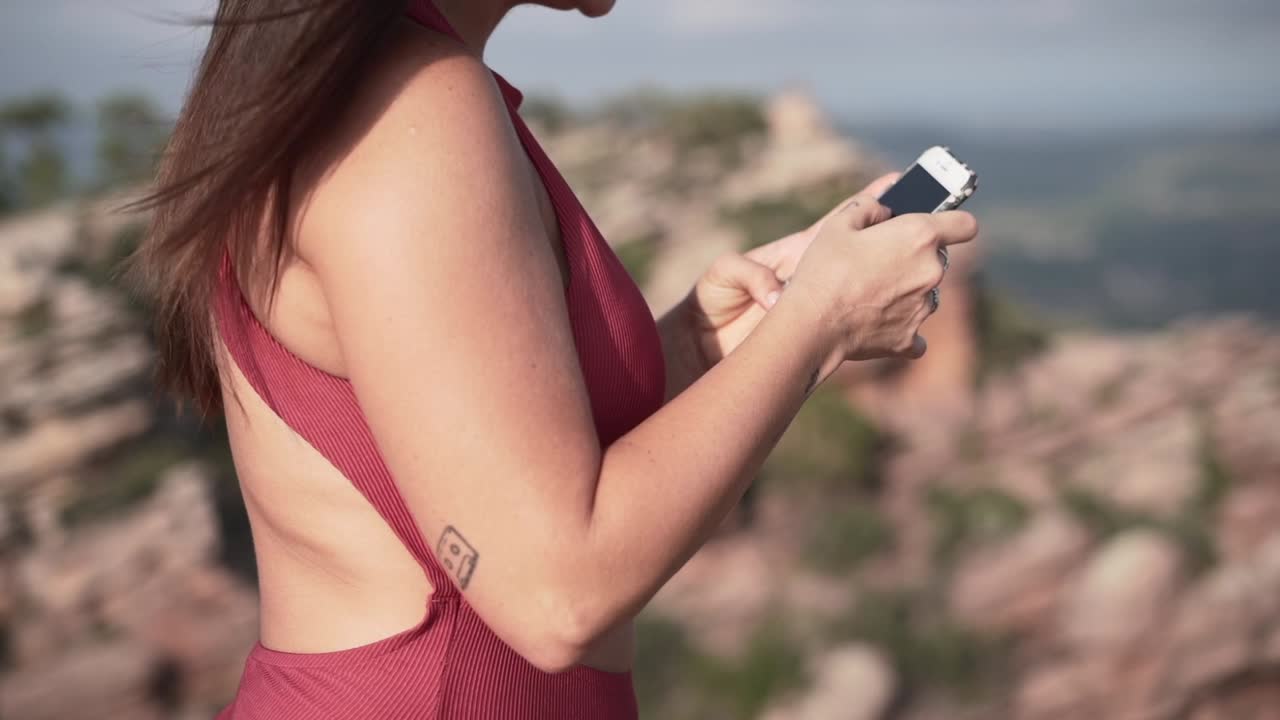 산 꼭대기 에서 전화 를 사용하는 여자