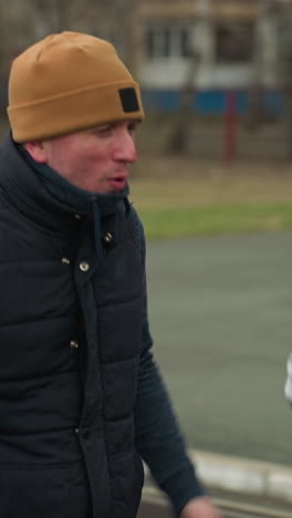 close-up of a coach jogging alongside a young boy in a stadium, the coach is engaged in conversation with the boy, who is smiling