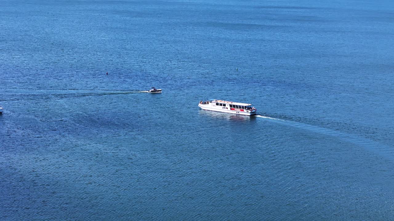 Private yacht and transportation vessel in middle of lake, aerial view