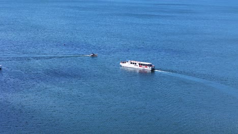 private yacht and transportation vessel in middle of lake, aerial view