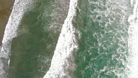Waves-breaking-near-the-shoreline-in-synchronized-formation-from-above