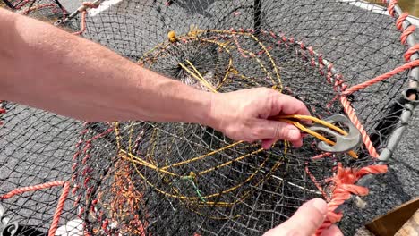 un pescador clasifica los peces y prepara las redes de pesca.