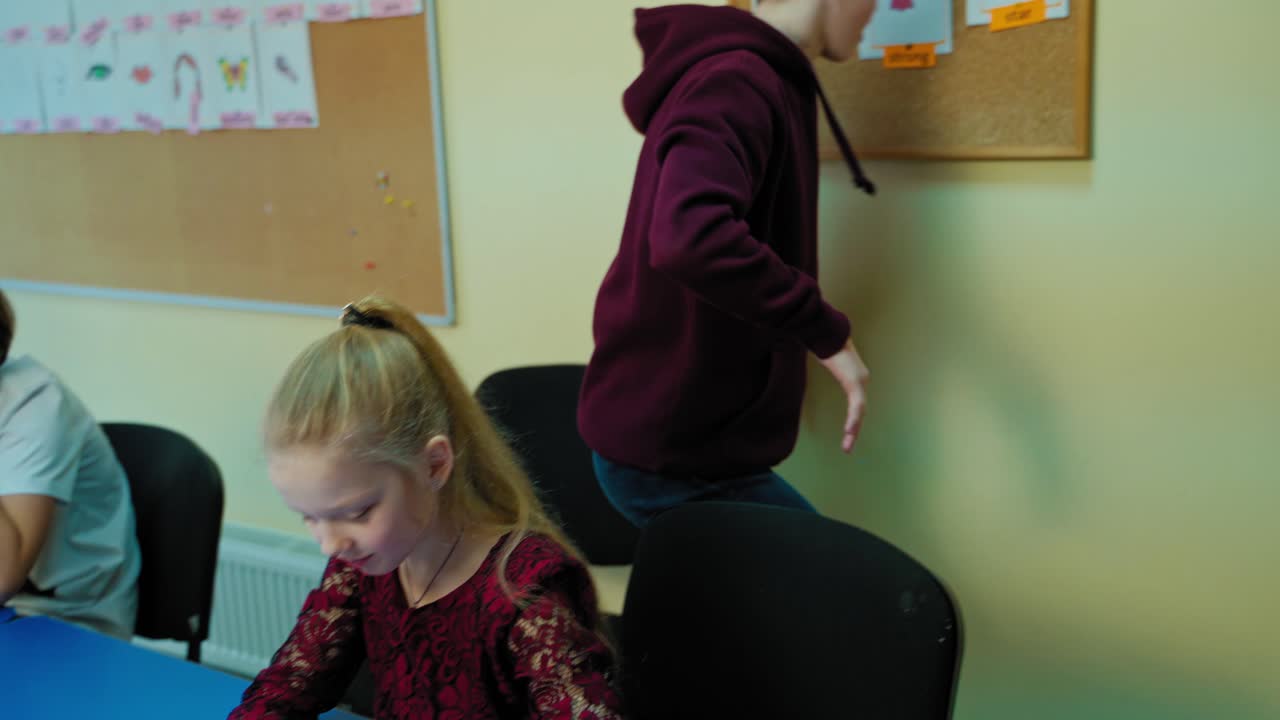 Students in the classroom. Teenage boy raising up his hand and goes to the board. Clever boy ready to answer during the lesson. Learning process at school.