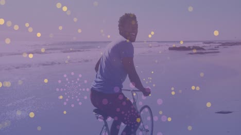 manchas amarillas de luz contra el retrato de un hombre afroamericano montando una bicicleta en la playa