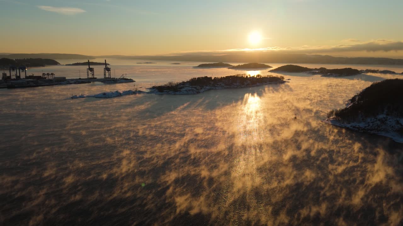 오슬로의 bjorvika 근처의 항구 위에서 황금 시간 해가 지는 빛과 함께 물 위에 떠있는 안개