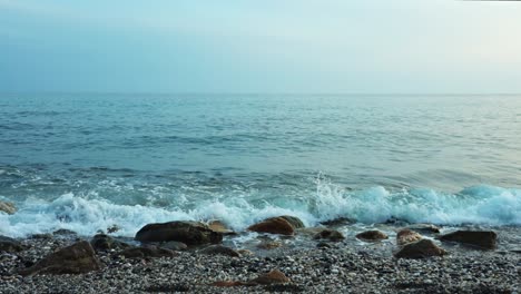 ocean waves at a rocky beach in slow motion during a dark day