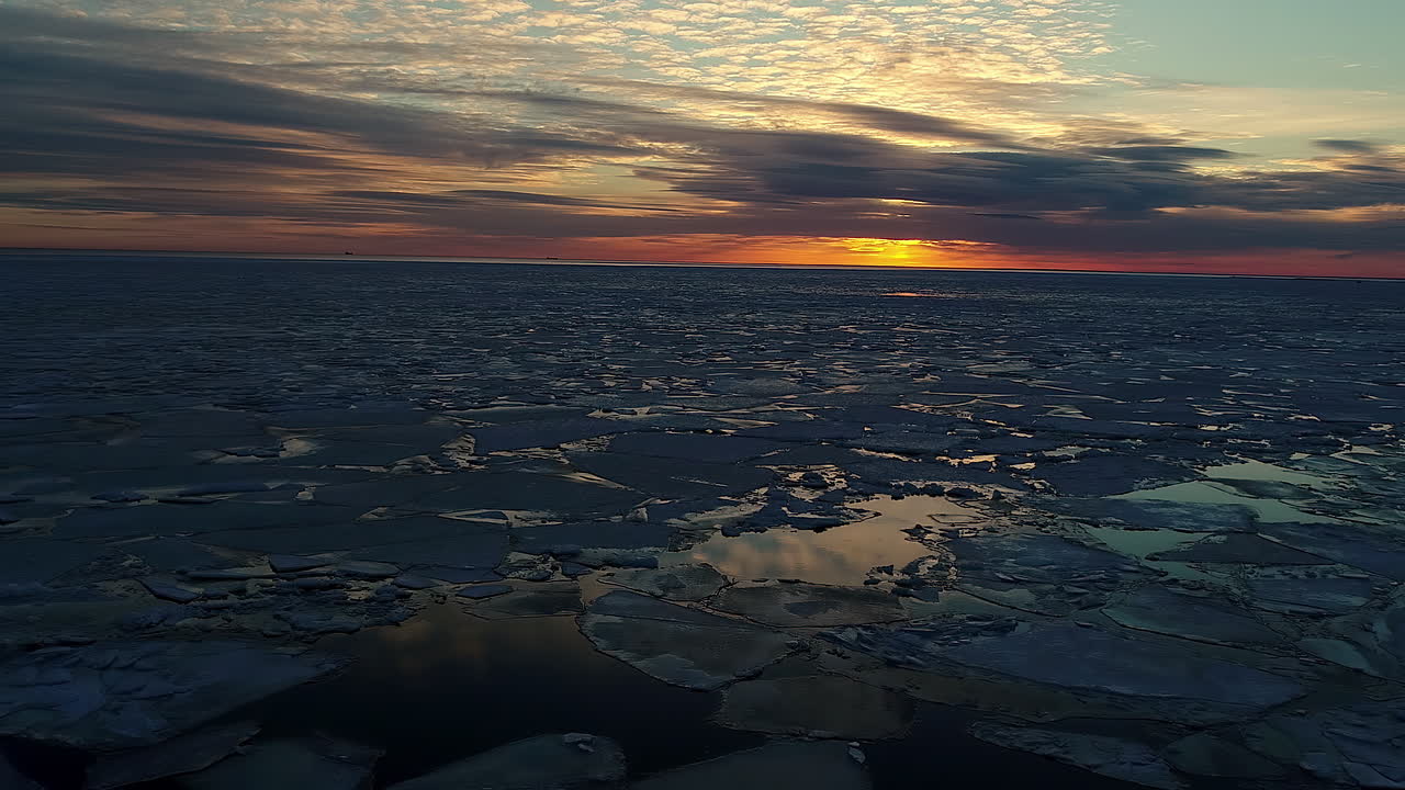 Aerial flyover melting ice floe and cubes during sunset time in Iceland - Environmental global warming