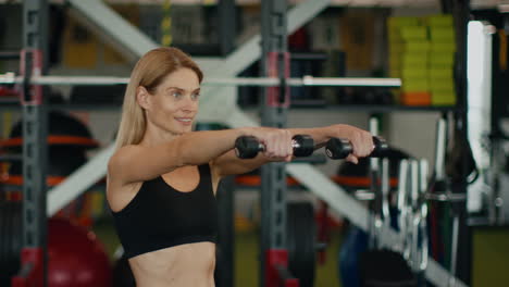 woman exercising with dumbbells in gym