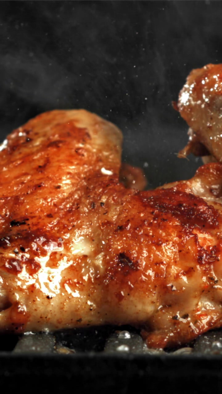 Ali di pollo dorate che sfrigolano su una griglia calda