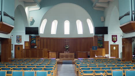 establishing shot empty modern church interior with seats and altar