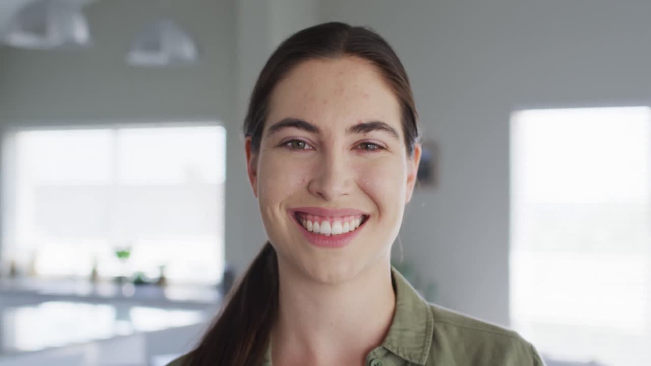 retrato de una mujer caucásica feliz mirando a la cámara en casa