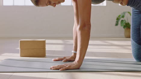 Gesunde-Yoga-Frau-Praktiziert-Die-Pose-Ihres-Kindes-Und-Genießt-Den-Fitness-Lebensstil,-Indem-Sie-Im-Studio-Trainiert-Und-Schönes-Körpertraining-Auf-Der-Trainingsmatte-Bei-Sonnenaufgang-Ausdehnt