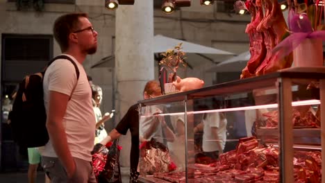 people shopping at an outdoor meat market