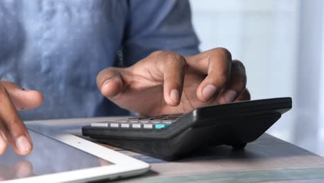 person using a calculator and tablet