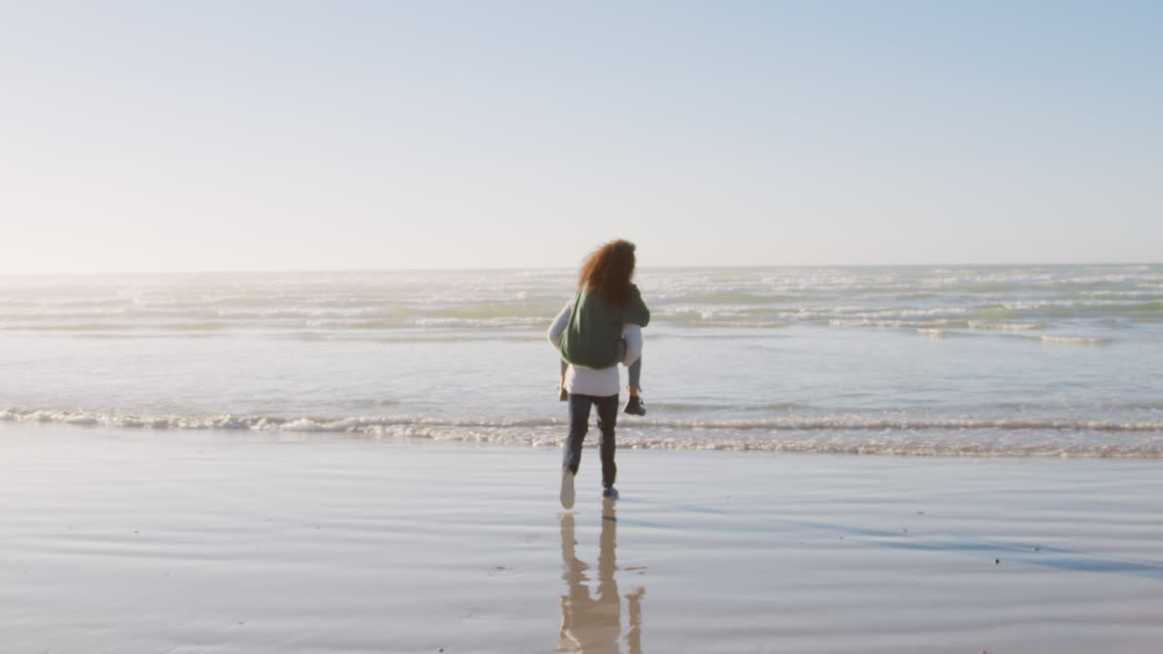겨울 해변 휴가 에 피기백 을  ⁇ 는 여자 를 주는 남자 의 뒷면
