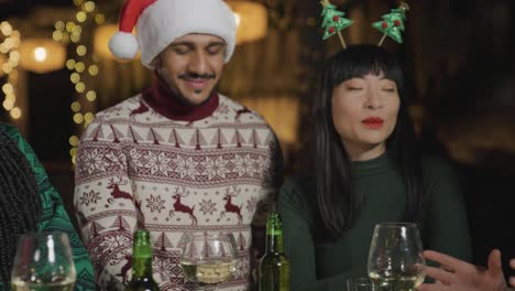 tracking shot along group of friends celebrating christmas at a bar