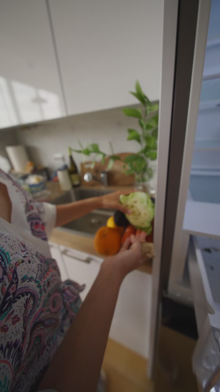Woman cleaning out an empty refrigerator with food