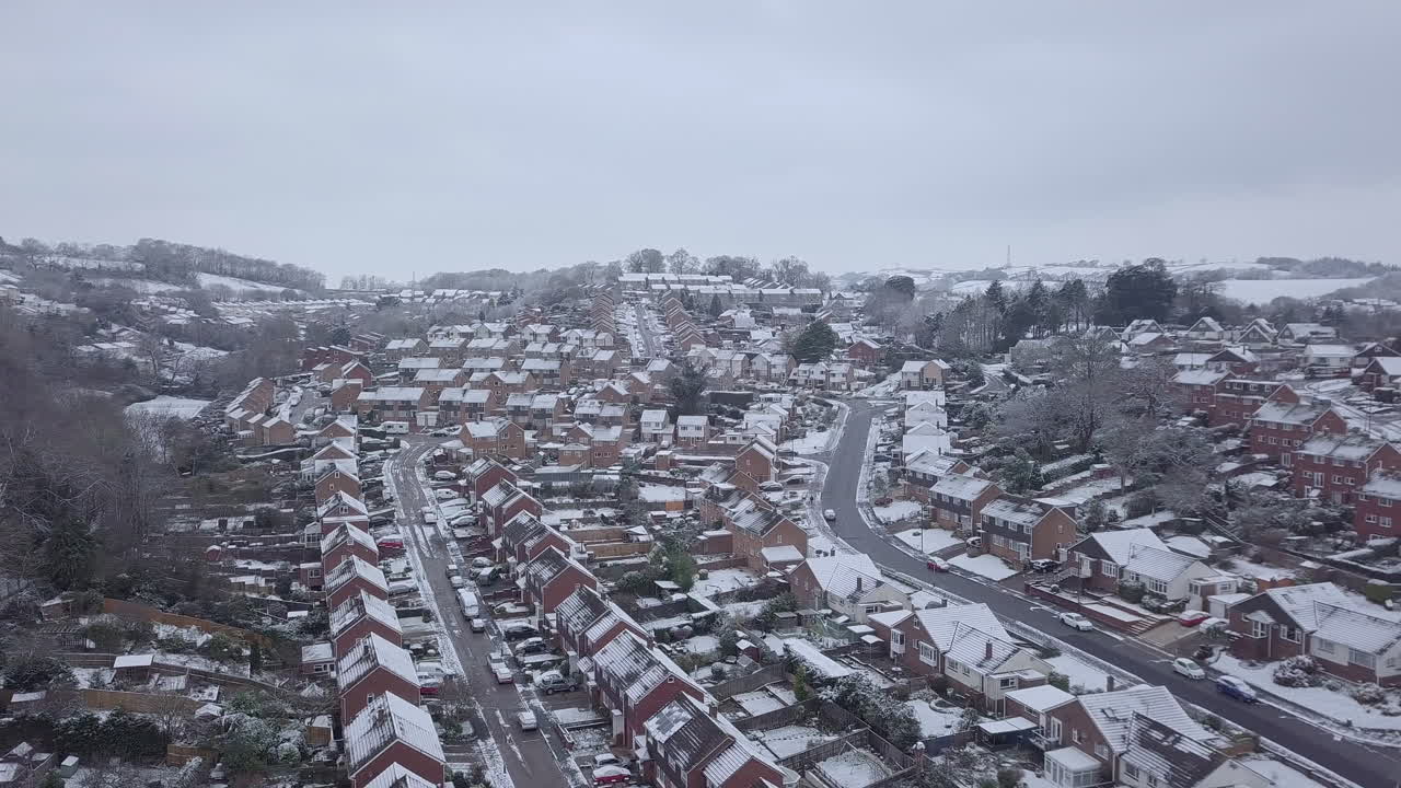 눈 덮인 엑서터 교외의 높은 측면 추적 드론 샷
