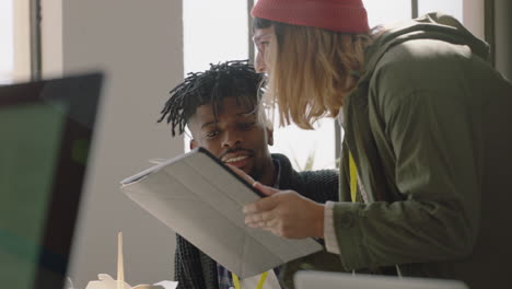 jeunes hommes d'affaires travaillant dans un bureau de démarrage chef d'équipe caucasien femme pointant vers l'écran d'une tablette montrant à ses collègues des idées créatives formation stagiaire brainstorming discutant d'informations