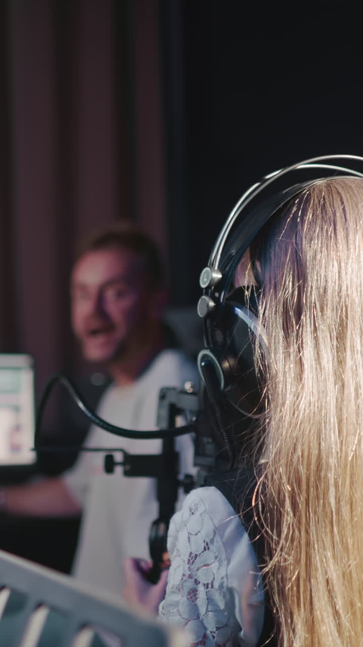 Girl stands in front of mentor honing vocal. Talented small student engages in vocal practice under guidance of tutor. Vocal cord training with teacher