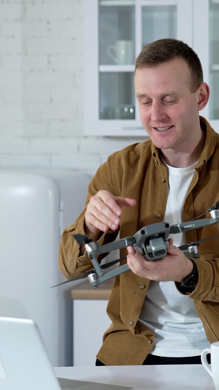 Kyiv, Ukraine, 2 May 2025: Man at home with drone. Young man playing with drone at home. Vertical video