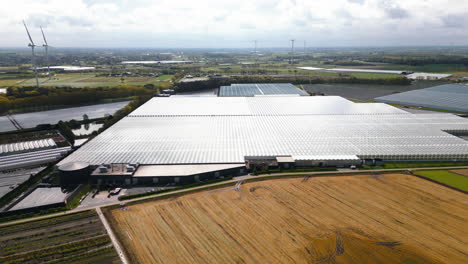 Industrial-area-with-greenhouses-and-farmland-in-Belgium,-aerial-view