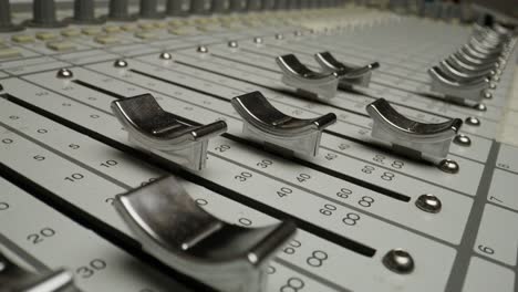 hand adjusting audio mixer faders