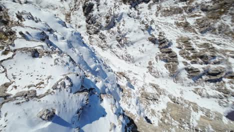 Acrobatic-fpv-drone-flying-over-Resegone-snowy-mountain-top-of-Italian-Alps-in-Italy-at-high-speed