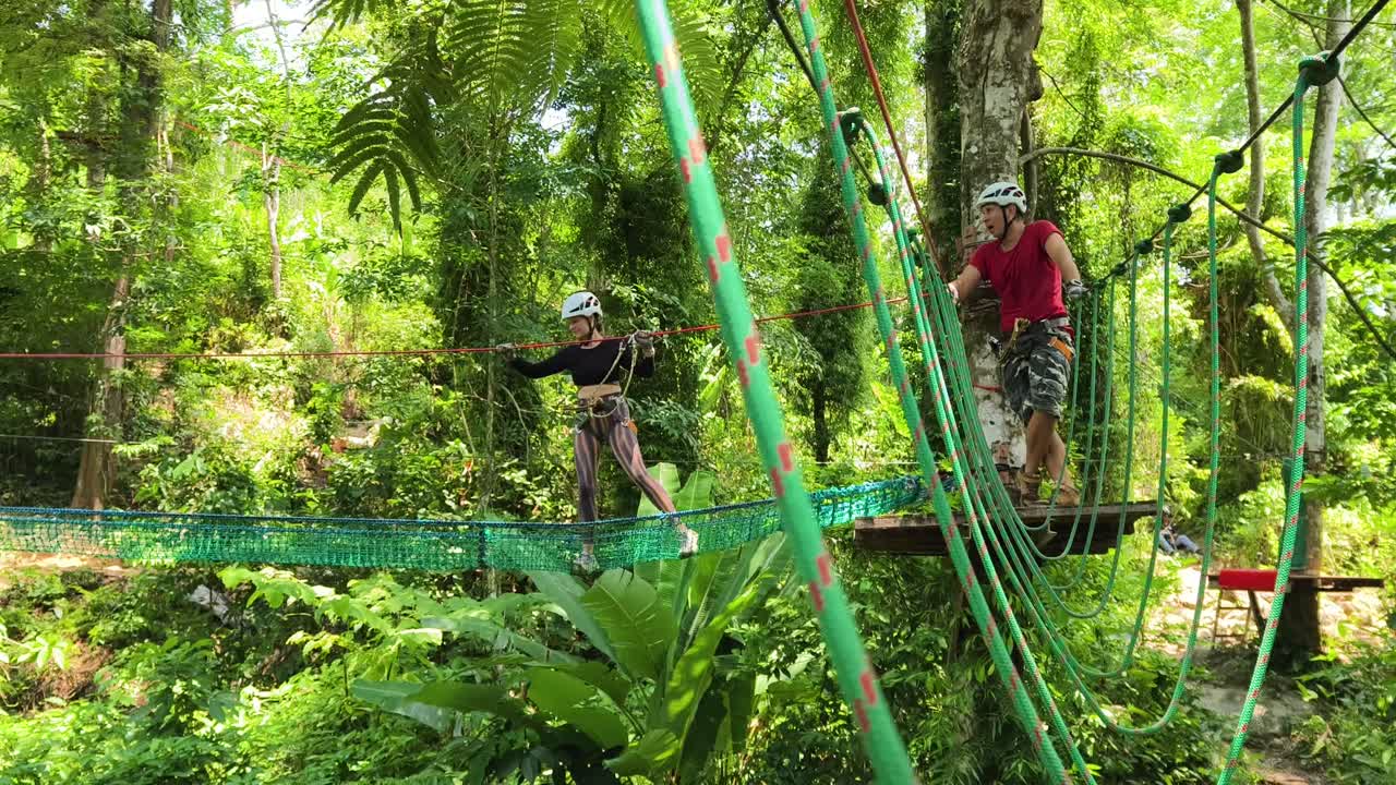 Couple enjoying a thrilling adventure course in a lush forest