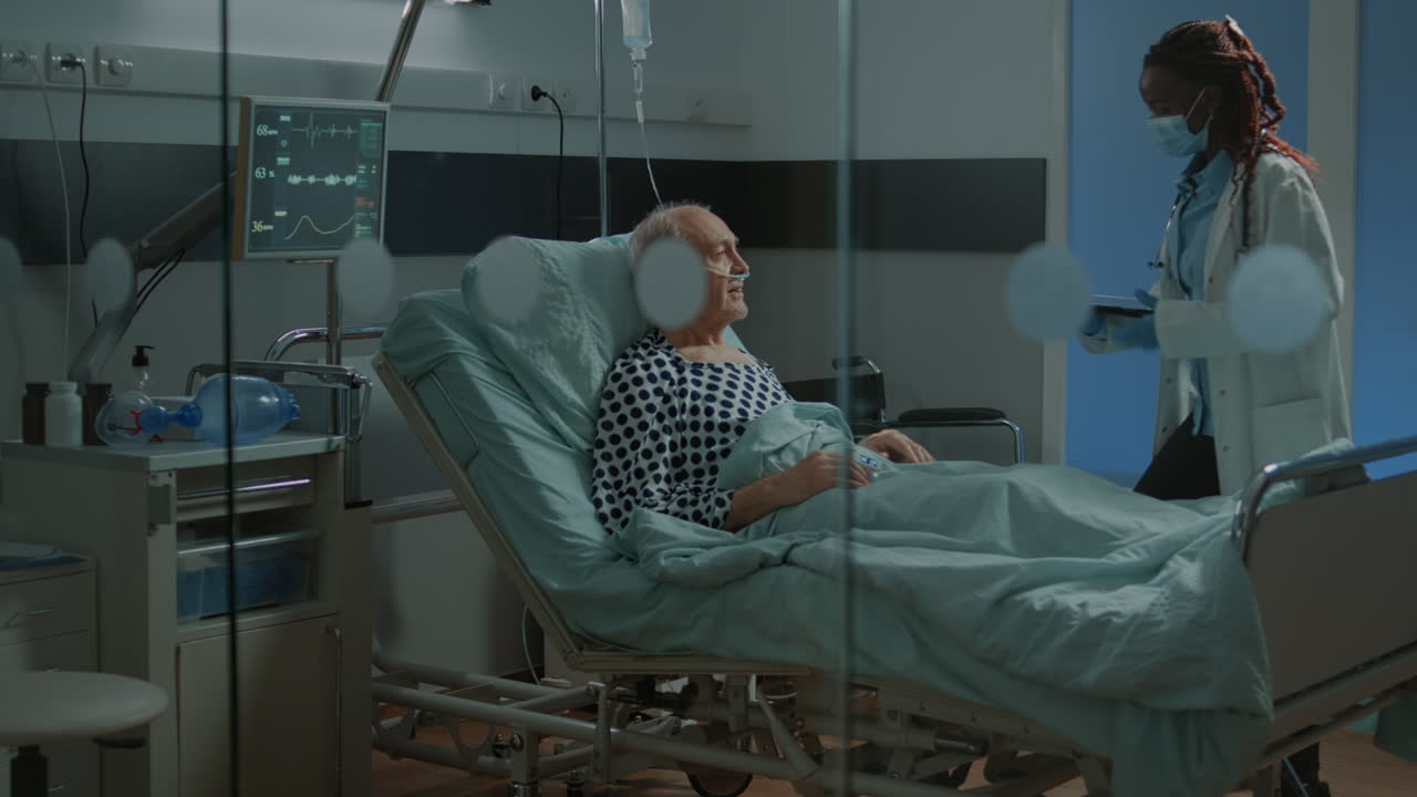 African american doctor fixing adjustable bed in hospital ward