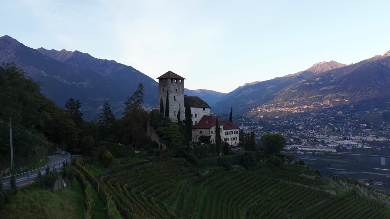 Schloss Lebenberg, Lebenberg Castle near the village of Tscherms in South Tyrol, Italy. On a moraine hill in front of the slopes of the Marlinger Berg. Dusk. Aerial video