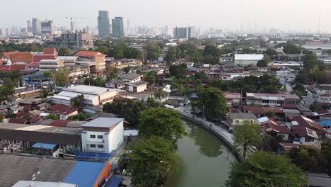 泰國農村地區的綠色樹木和房屋包圍的街道附近停<unk>的運河水 - 空中拍攝