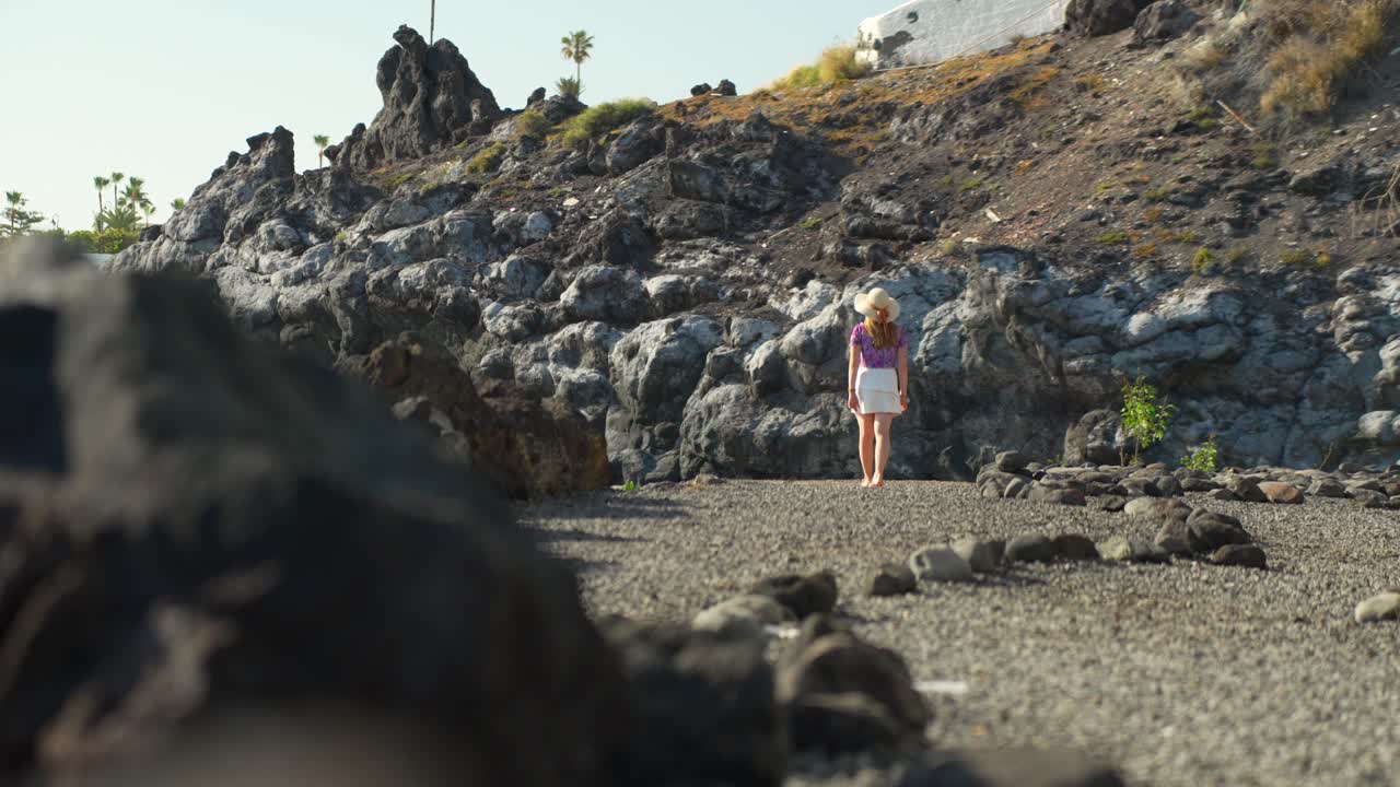 playa tropical de tenerife con mujer de vacaciones usar sombrero de verano y falda caminando
