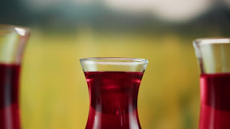 pouring a red hot beverage into a glass