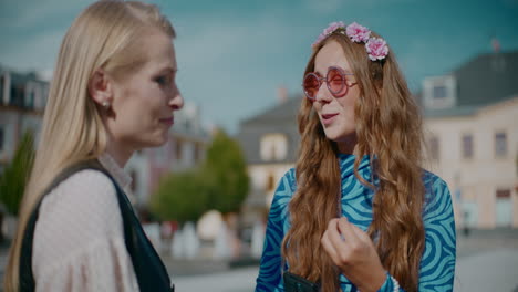 two women talking in a city square