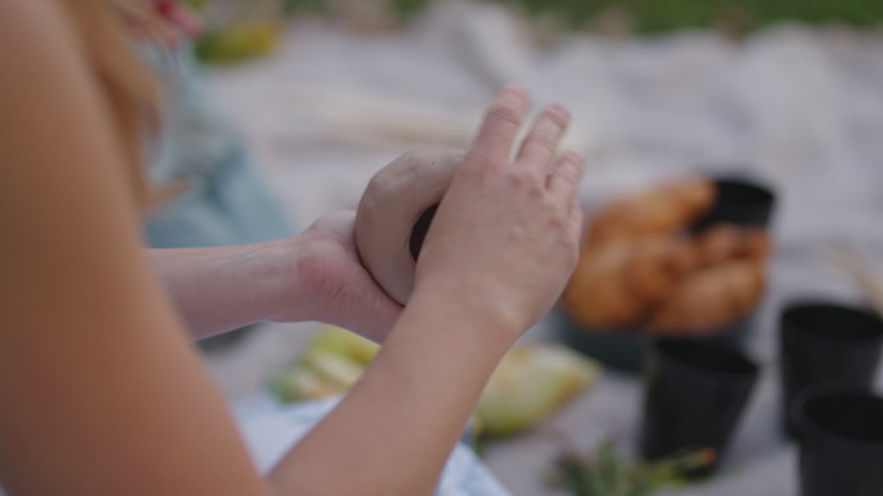 여성들은 자연에서 점토로 조각합니다. 열린 공간에서. 점토 모델링을 훈련하는 소녀 그룹 취미 창의력 수작업. 제품의 클로즈업 모델링.