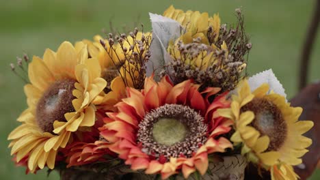vibrant sunflower bouquet with orange tones and dried flowers in rustic woven basket