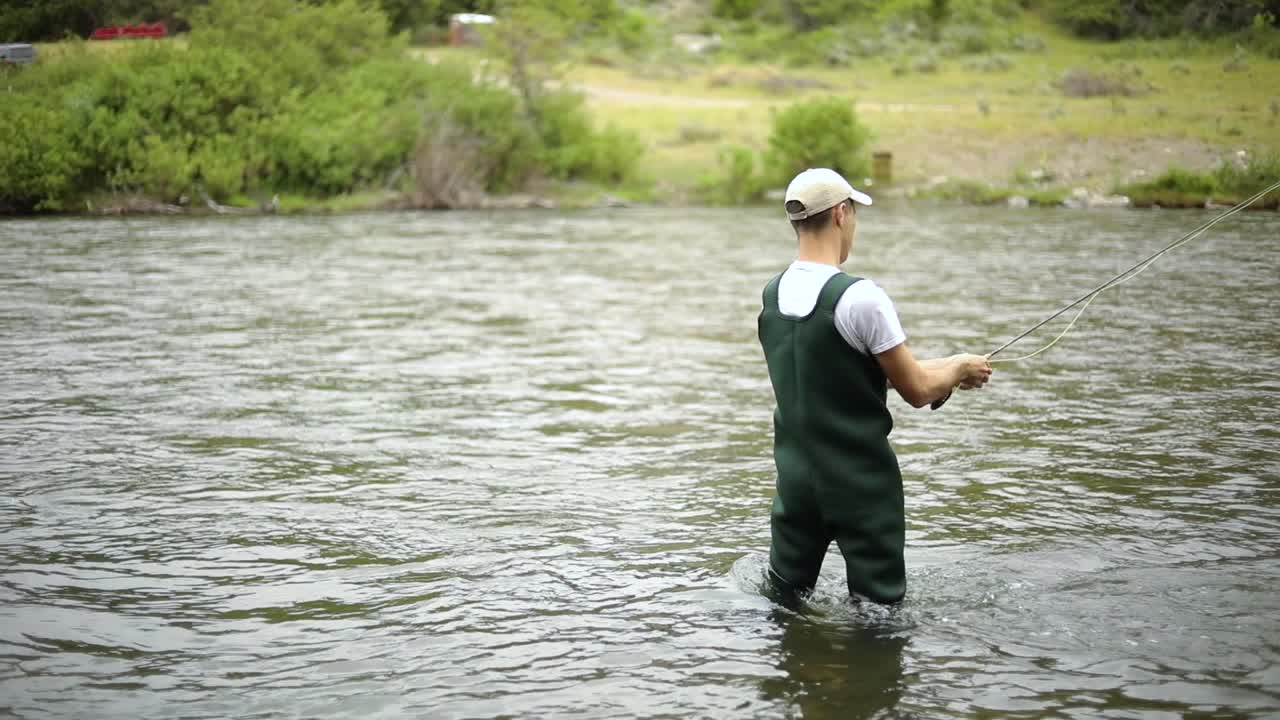 toma en cámara lenta de un pescador caucásico lanzando su anzuelo mientras pesca con mosca-1