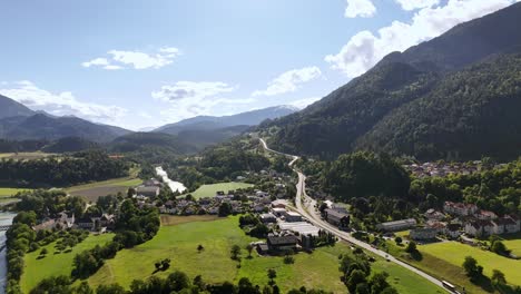 tamins, switzerland with mountains, river, and lush greenery on a sunny day, aerial view